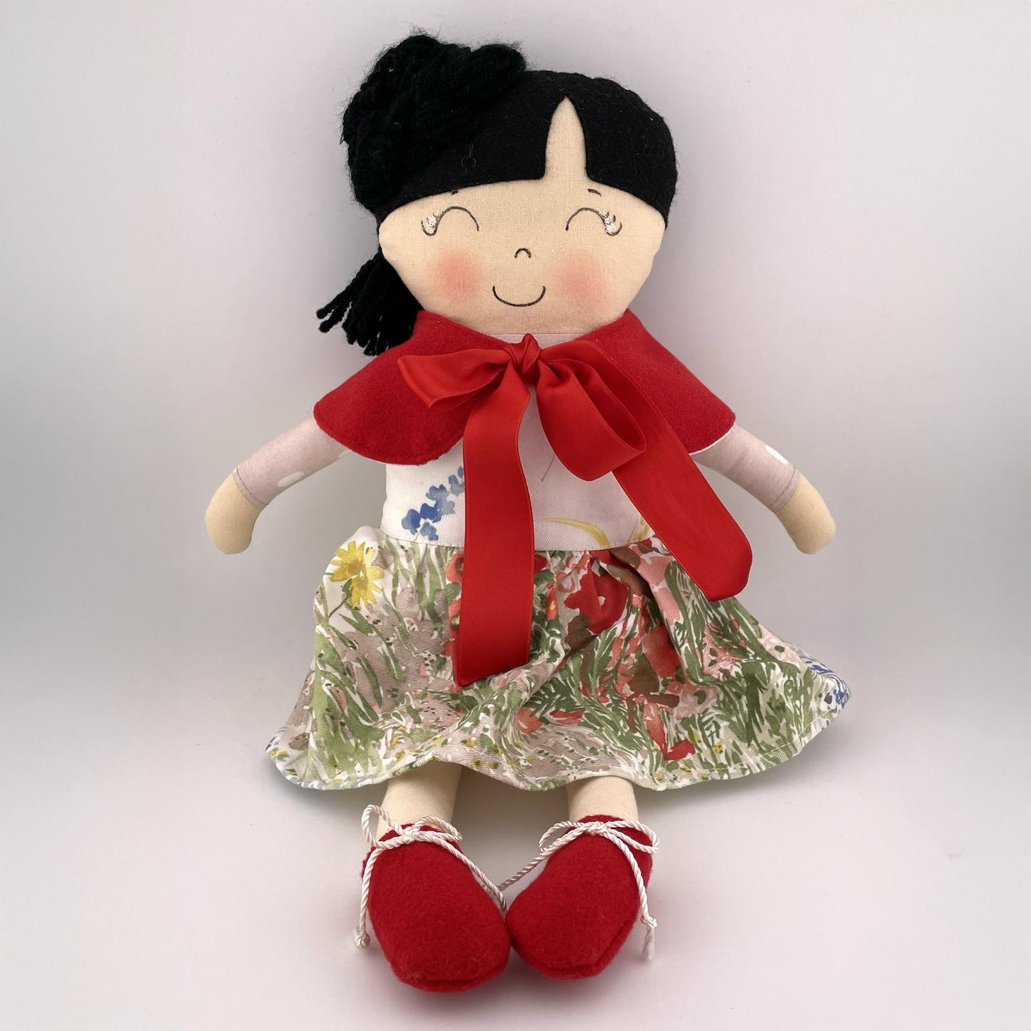 Bambola di stoffa con gonna floreale